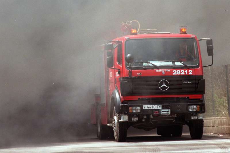 Un cami�n de bomberos sale de la intensa humareda. Archivo/EFE/J.C.Cardenas.
