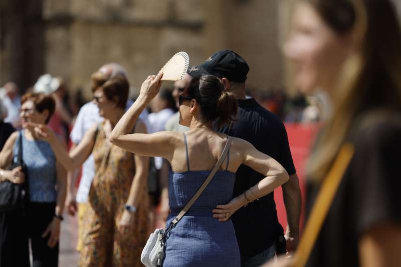 Una viandante se protege del sol mientras pasea por Valncia. EFE Ana Escobar
