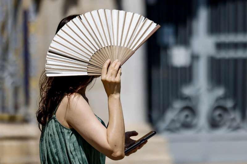 Una mujer se protege del intenso calor con un abanico en Valencia. EFEAna EscobarArchivo

