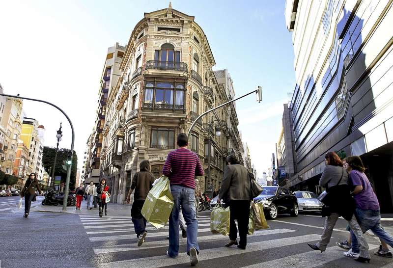 Numerosas personas cruzan una calle del centro de València tras realizar sus compras. EFE/ Manuel Bruque/Archivo
