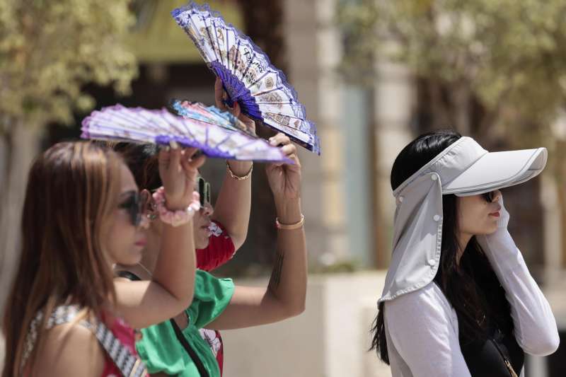 Unas turistas se protegen del sol y del calor con abanicos y gorras en un ada de calor en Valencia. EFEAna Escobar
