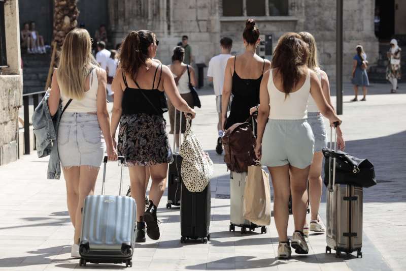 Un grupo de turistas caminan con sus maletas por el centro de València. EFE/Ana Escobar
