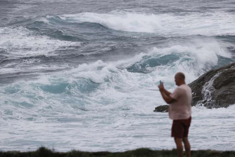 Una persona fotografía las olas en un día de fuerte viento. EFE/Lavandeira jr/Archivo
