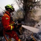 Imagen de archivo de un bombero durante las labores de extinción de un incendio forestal. / EFE-Natxo Frances