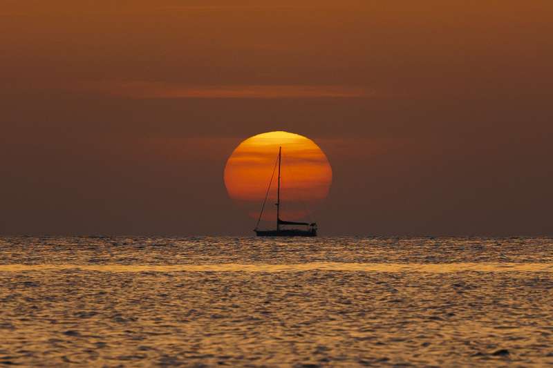 Un barco navega al amanecer frente a la playa de Las Rotas de Denia (Alicante). EFE/Biel Aliño/Archivo
