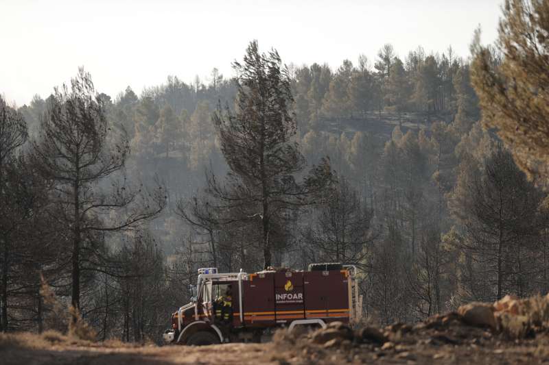 Bomberos en el retén mientras espera el relevo tras pasar la noche trabajando en el incendio en la zona de los Peiros, en la provincia de Teruel. EFE/Manuel Bruque