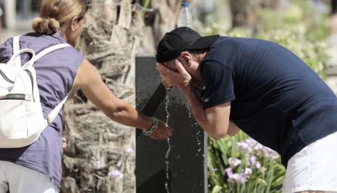 Dos personas se refrescan en una fuente del centro de Valencia en un día de mucho calor. / EFE-Ana Escobar-Archivo