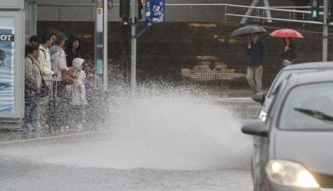 Varias personas se resguardan de la lluvia en una parada de autobús en Alicante. EFE/Morell
