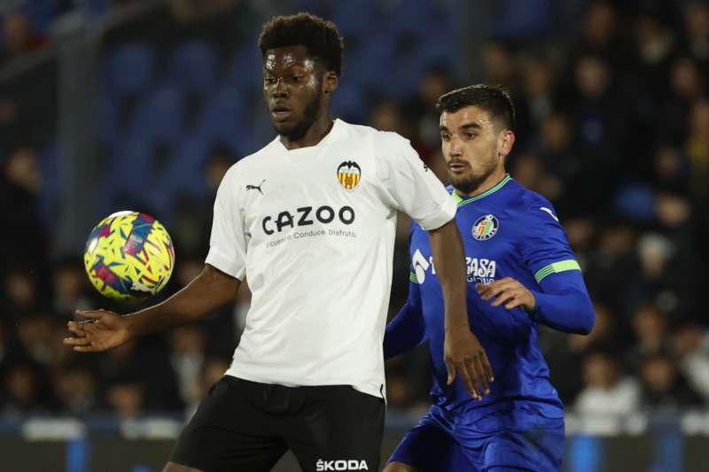 El centrocampista estadounidense del Valencia, Yunus Musah (i), protege el balón ante el centrocampista uruguayo del Getafe, Mauro Arambarri. EFE / Archivo
