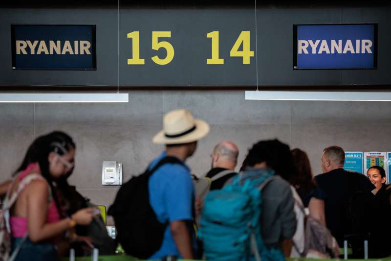 Turistas hacen cola en un mostrador de aerolínea en el aeropuerto de Manises (Valencia). 