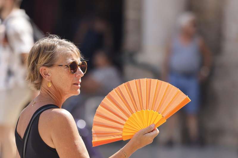 Una mujer trata de refrescarse usando un abanico en entro de la ciudad de Valencia. EFE/Ana Escobar/Archivo
