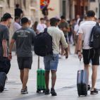 Varios turistas transitan por el centro de Valencia con sus maletas de cabina. EFE/Biel Aliño/Archivo

