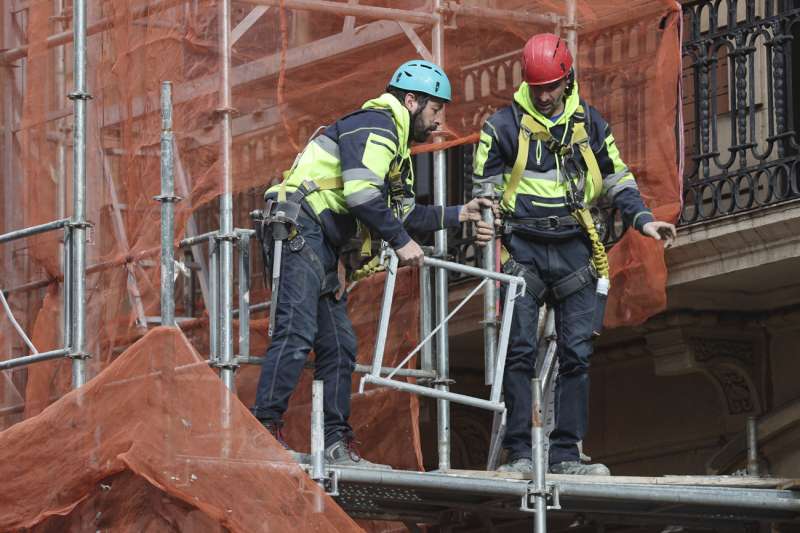 Dos trabajadores retiran un andamio, este martes. EFE/Luis Tejido
