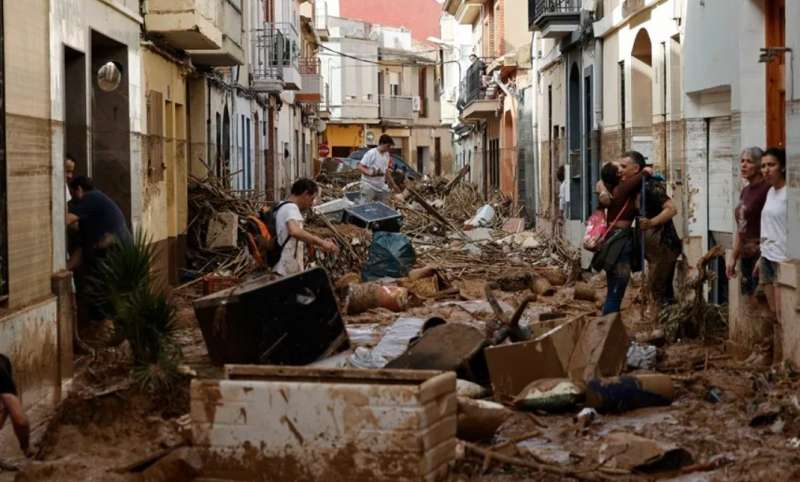 Varias personas participando en las tareas de limpieza y desescombro tras la riada en Paiporta (Valencia). EFE / Biel Aliño