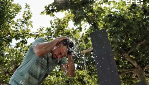 Un hombre se refresca en una fuente para combatir el calor. / EFE-Jesús Digues 