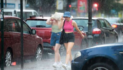 Imagen de archivo de dos chicas bajo la lluvia. / EPDA