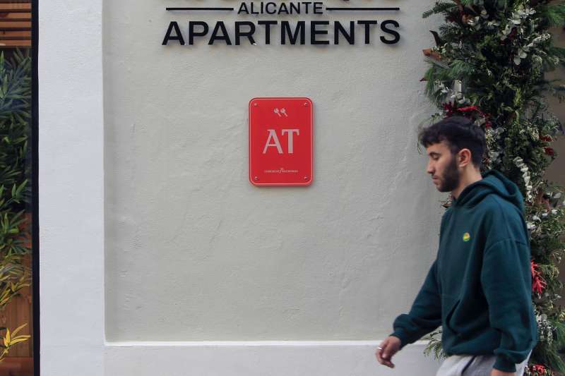 Un joven pasa ante un edificio de apartamentos de Alicante. EFE/ Morell
