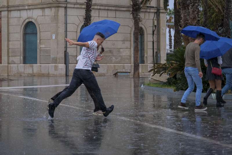 Una persona se protege de la intensa lluvia este viernes en Alicante, provincia azotada por la dana Alice. EFE/Pablo Miranzo