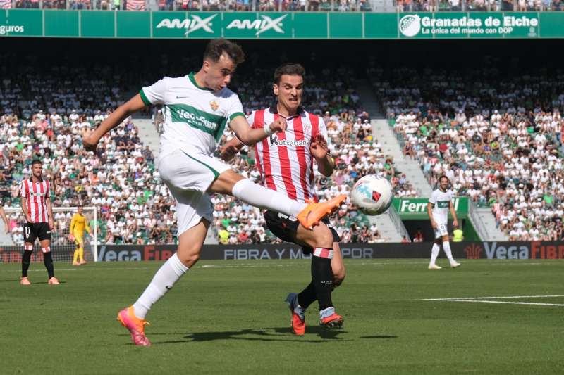 El centrocampista del Elche A. Febas (i) ante Galarreta durante el partido correspondiente a la jornada 9 de LaLiga entre el Elche y el Athletic, este domingo, en el estadio Manuel Martínez Valero de Elche. EFE/ Pablo Miranzo