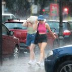 Dos personas caminan bajo la tormenta en una imagen de archivo. EFE/Biel Aliño/Archivo