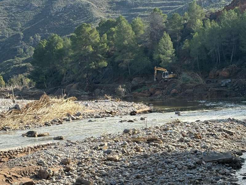 Una máquina trabaja en el río Túria, a su paso por Bugarra, para limpiar los efectos de la dana. / EPDA