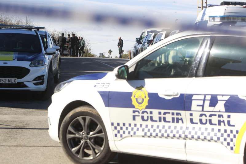 Agentes de la Policía Local de Elche vigilan una vivienda en la que se han encerrado dos hombres, tras presuntamente haber matado a dos hombres y herir de gravedad a un tercero. EFE/ Morell
