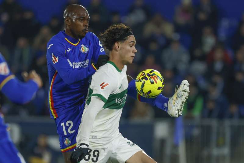 El defensa del Elche Héctor Fort pelea por el balón con el defensa camerunés del Getafe, Allan-Roméo Nyom. EFE/Archivo