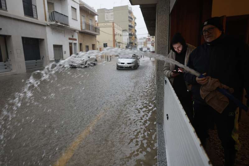 Unas personas achican agua de un garaje en la localidad de l"Alcúdia en una imagen de archivo. EFE/ Kai Forsterling/Archivo