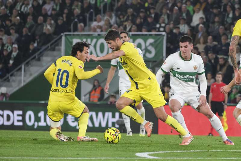 El centrocampista del Villarreal Santiago Comesaña (2i) se escapa con el balón durante el partido de fútbol de LaLiga contra el Elche. EFE / Pablo Miranzo