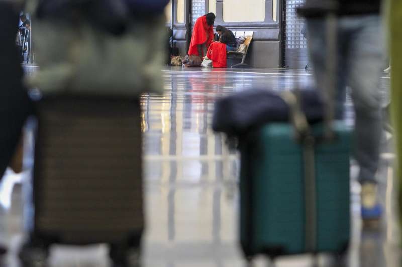 Dos pasajeros aguardan en la estación de Alicante donde Cruz Roja Comunitat Valenciana ha instalado puntos de atención. Archivo/EFE/MORELL
