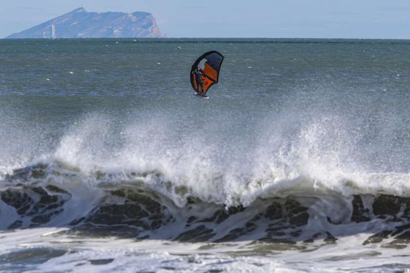 En la imagen, de estos días, un surfista aprovecha el fuerte viento para disfrutar de su afición con la Serra Gelada al fondo. EFE/Pep Morell
