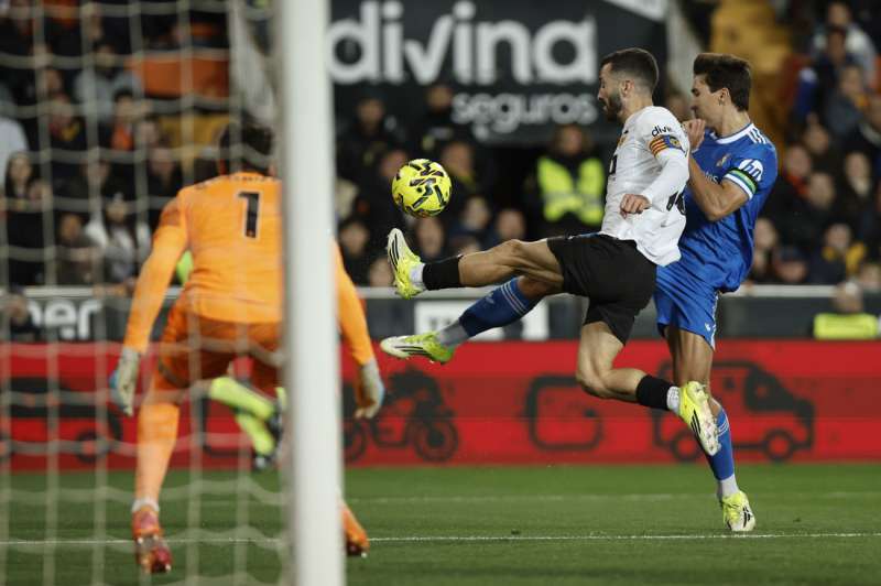 El lateral del Valencia José Gayá (c) pelea un balón con Gonzalo García (d), del Real Madrid, durante el partido de LaLiga de fútbol que Valencia CF y Real Madrid disputan en el estadio de Mestalla. EFE/Biel Aliño
