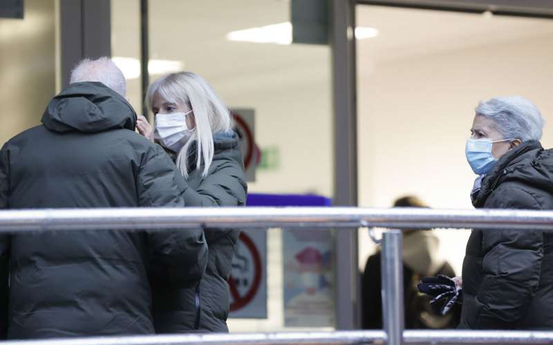 Una persona coloca una mascarilla a otra al entrar en un centro de salud. EFE/Luis Tejido/Archivo
