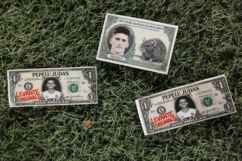 Reproducciones de billetes con la cara del jugador del Valencia Pepelu tras ser lanzados al terreno de juego. EFE/Ana Escobar