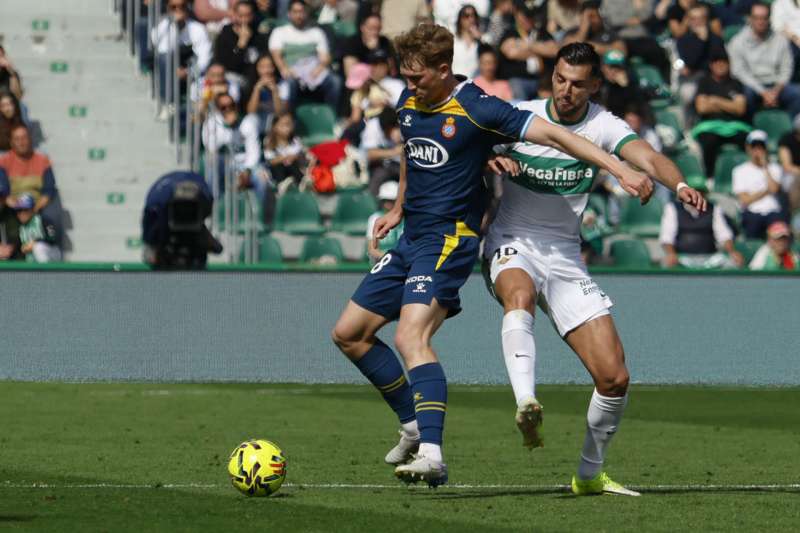 El defensa alemán del RCD Espanyol Clemens Riedel (i) y el delantero del Elche Rafa Mir (d) durante el partido de Liga disputado este domingo en el estadio Martínez Valero de Elche. EFE/Pablo Miranzo
