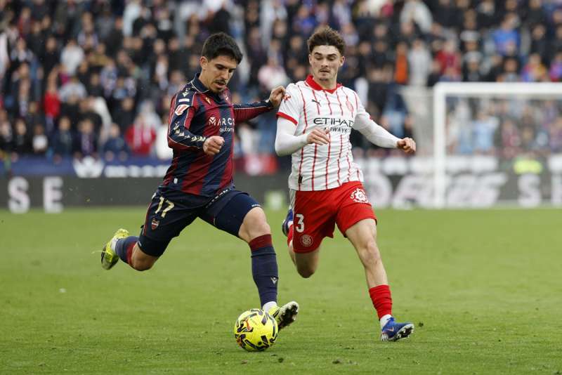 El defensa del Girona Joel Roca (d) pelea un balón con el defensa del Levante Víctor García. EFE/ Ana Escobar
