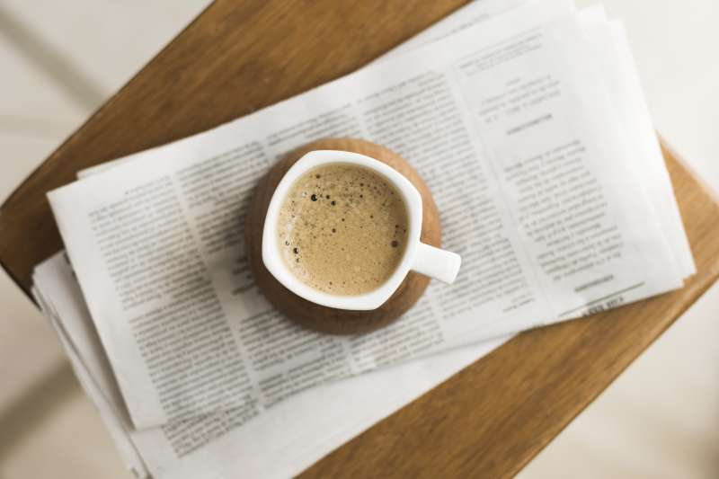 Imagen de archivo de una taza de café sobre un periódico. /FREEPIK