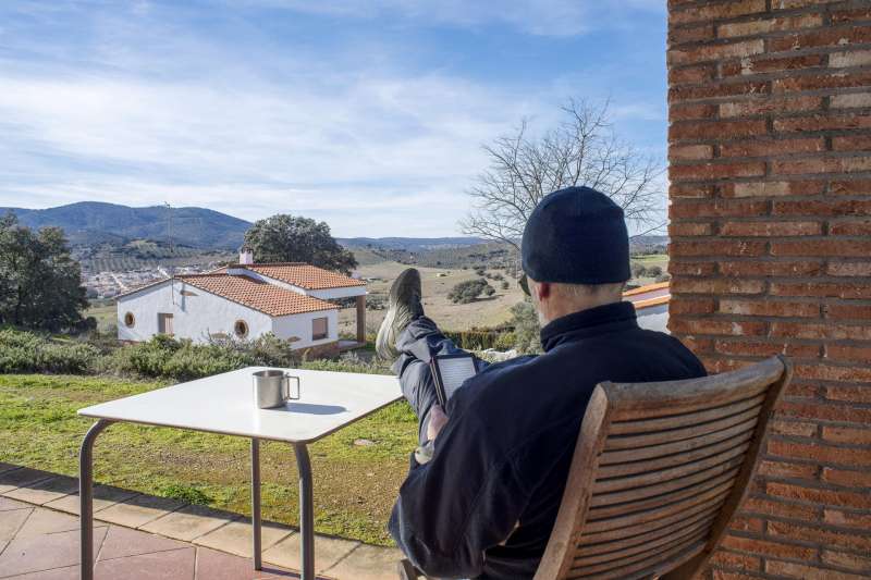 Una persona descansa en el porche de una casa rural. EFE/José Manuel Pedrosa/Archivo
