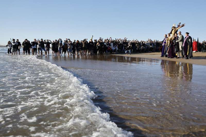 Miembros de la Hemandad del Santísimo Cristo del Salvador acercan la talla al agua durante la procesión del Santísimo Cristo del Salvador de la Semana Santa Marinera este Viernes Santo en Valencia. EFE/ Ana Escobar
