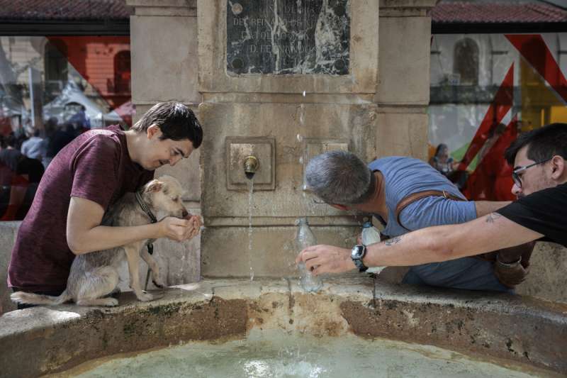 Varias personas se refrescan en una fuente en la localidad valenciana de Xàtiva. EFE/Biel Aliño/Archivo