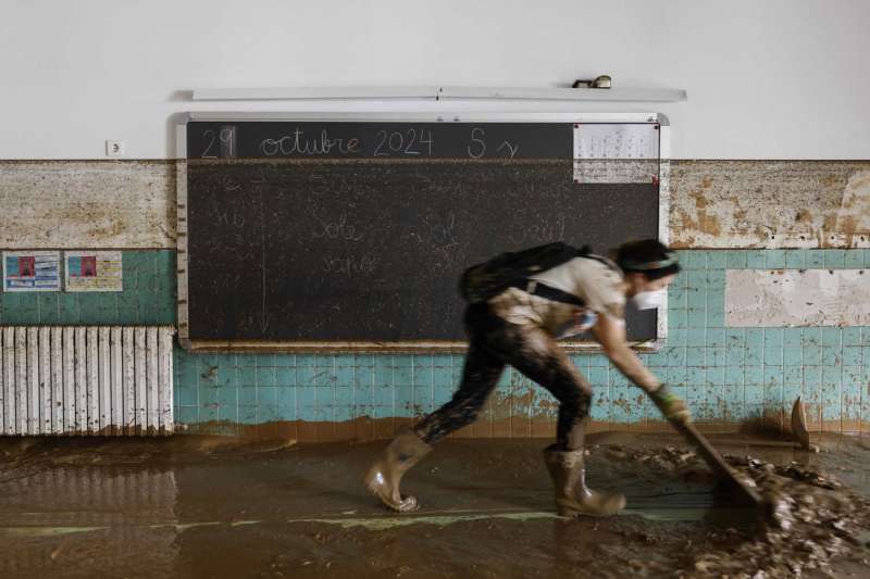 Imagen de una mujer en las labores de limpieza del lodo en un colegio de Sedaví. EFE/Archivo/Ana Escobar
