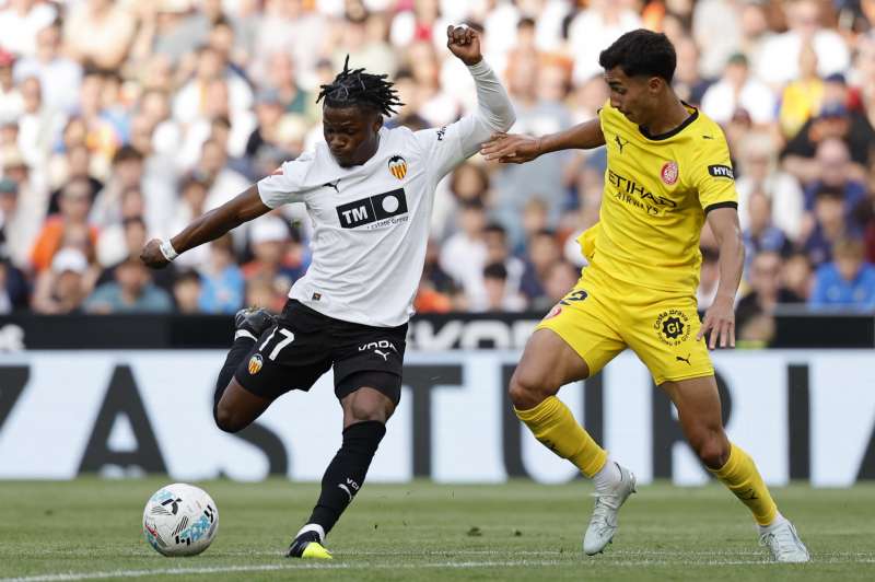 El delantero del Valencia Largie Ramazani (i) disputa un balón con el defensa del Girona Vitor Reis (d) durante el partido de LaLiga entre Valencia CF y Girona FC celebrado este sábado en el estadio de Mestalla, en Valencia. EFE/ Ana Escobar

