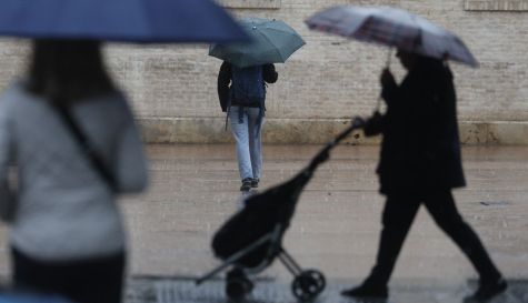 Varias personas se protegen de la lluvia este sábado en Valencia.