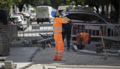Un trabajador de la construcción bebe agua para combatir el calor en una calle del centro de Valencia.