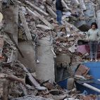 Una mujer observa los destrozos causados por los terremotos en Venezuela entre los escombros de edificios colapsados en una de las zonas más afectadas por la catástrofe.