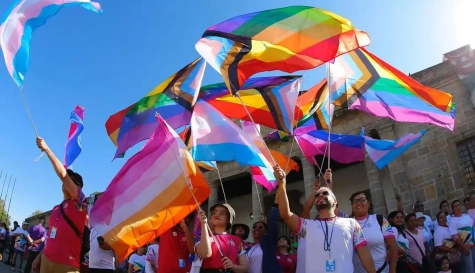 Deportistas de los Gay Games alzan banderas relacionadas con el colectivo LGTBIAQ+.