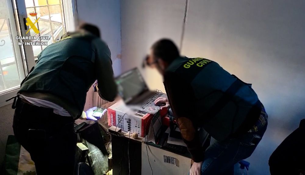 Agentes de la Guardia Civil analizan uno de los dispositivos incautado al ciberpederasta detenido en Alicante que engañó a más de 20 víctimas durante una década. / EFE-Guardia Civil