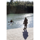 Dos agentes de la Policia Nacional realizan tareas de búsqueda en el río Júcar. / EFE-Natxo Francés