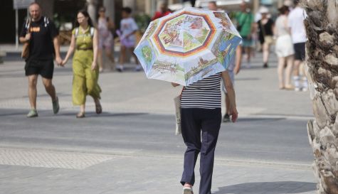 Imagen de una viandante que se protegía del sol en Alicante, este jueves. / EFE-Morell