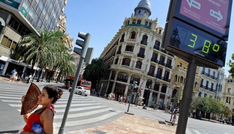 Una joven se abanica ante un termómetro que marca 38 grados.